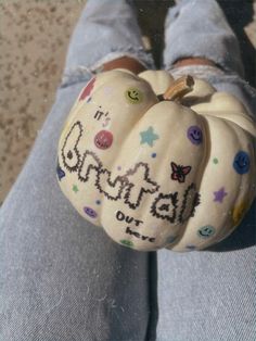 someone is holding a painted pumpkin with the word carnival out on it's side