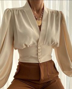 RITA BUTTONED SHIRT has an elegant fit, lantern sleeves.?   Puff Sleeve  V-neck  Buttoned  Stretchy cuffs   Cotton mix?      SIZE LENGHT BUST SLEEVE   S cm 54 90 62   inches 21.3 35.4 24.4   M cm 55 94 63   inches 21.7 37 24.8   L cm 56 98 64   inches 22 38.6 25.2   XL cm 56 102 65   inches 22 40.2 25.6   XXL cm 57 106 66   inches 22.4 41.7 26   3XL cm 58 110 67   inches 22.8 43.3 26.4    CARE INSTRUCTIONS: Don't Bleach, Don't dry clean, Don't iron, for better washing results use the hand wash a Blouse Summer, Coffee Fashion, Tunic Tops Casual, Mini Dress Formal, Khaki Fashion, Beige Style, 2022 Fashion, Elegant Blouses, Hot Dress