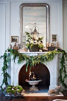 a fireplace decorated with greenery and candles