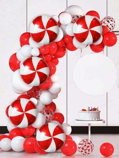 a bunch of balloons that are in the shape of a candy cane arch with red and white balls