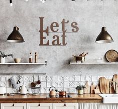 a kitchen with wooden counters and hanging lights above the counter top, next to an art piece