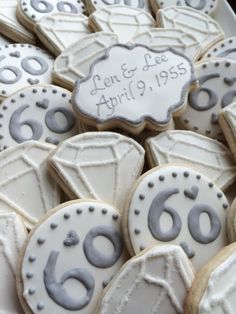 decorated cookies with white frosting and gray icing are arranged on a platter