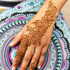 a woman's hand with henna tattoos on it