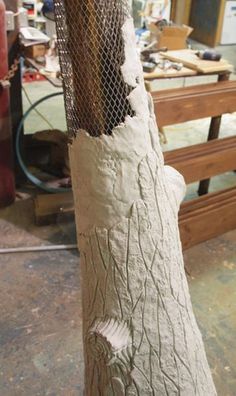 a piece of wood that has been carved to look like a tree trunk with wire netting around it