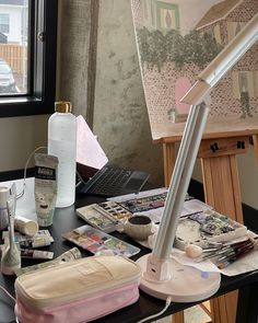 an easel is sitting on a table with art supplies