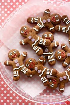 several decorated gingerbreads in a plastic container on a pink polka dot tablecloth