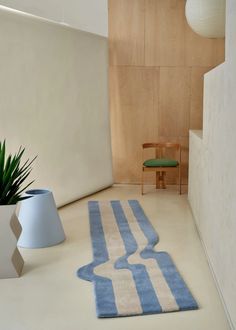 a blue and white rug sitting on top of a floor next to a green chair