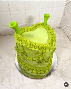 a green cake sitting on top of a white counter