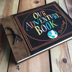 an adventure book is sitting on a wooden table