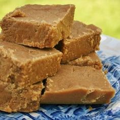 several pieces of peanut butter fudge on a blue and white plate with grass in the background