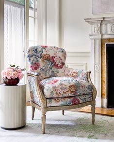 a chair with flowers on it in front of a window