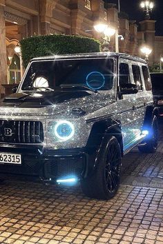 a black suv parked in front of a building with lights on it's grille