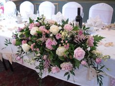 the table is set with white and pink flowers