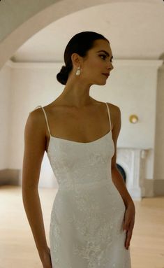 a woman in a white wedding dress is looking off to the side with her hand on her hip