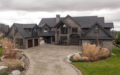 a large house with lots of windows and stone walkway leading to the front yard area