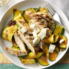 a white plate topped with zucchini and chicken