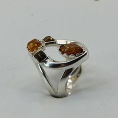 This is a beautiful Baltic Amber Ring in 925 Sterling Silver. The Amber is right from the capital of amber and silver: the city of Gdańsk / Danzig in Poland. The ring is made out of solid 925 Silver and there is no nickel or other substances causing most allergies in the silver. This makes the ring hypo allergenic. Size of the Amber 1 x 0.8 x 0.4 cm 1 x 0.4 x 0.4 cm 2 x 0.3 x 0.3 cm 1 x 0.31 x 0.16 inch 1 x 0.16 x 0.16 inch 2 x 0.13 x 0.13 inch Weight of the Ring 4.4 grams 0.16 ounces You will receive the item in a gift box - perfect to surprise someone or yourself. Usually we ship on the same day we receive the payment for the order. We want you to be happy with your purchase. If you do not like what you bough can send it back and we will refund you the money. Please do not hesitate to co Amber Open Ring For Anniversary, Silver Baltic Amber Rings As Gift, Amber Sterling Silver Rings For Anniversary, Amber Sterling Silver Ring With Polished Finish, Unique Amber Sterling Silver Rings, Baltic Amber Ring For Anniversary, Yellow Multi-stone Sterling Silver Rings, Sterling Silver Amber Gemstone Rings, Amber Gemstone Ring In Sterling Silver