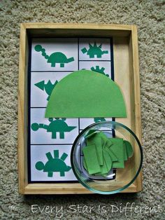 an image of a green umbrella in a box on the ground with paper cut outs