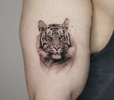 a black and white tiger tattoo on the left side of the right arm, it looks like he is staring straight ahead