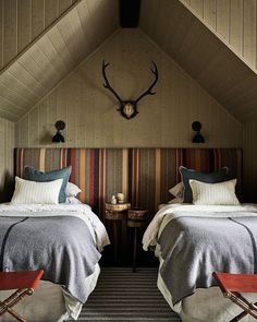 two beds in a room with striped headboards and pillows on top of each bed