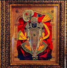 an ornate painting on display in a gold and red frame, depicting the god ganesha