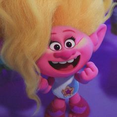 a close up of a troll doll with blonde hair and big eyes, on a purple background