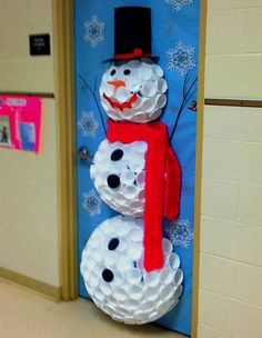 two snowmen made out of toilet paper on the floor in front of a blue door