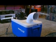 a cooler sitting on top of a carpet covered floor next to a tv and speakers