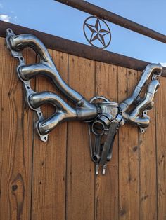 a close up of a metal object on a wooden wall with a star above it