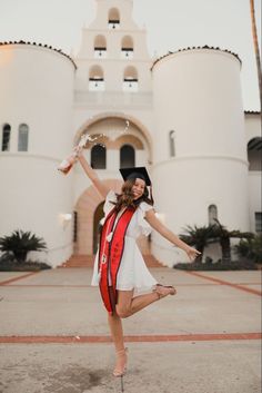 a woman in a graduation gown is dancing