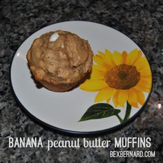 a banana peanut butter muffin on a plate with a sunflower painted on it