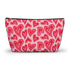 a pink and red heart print cosmetic bag with zippered closures on the front