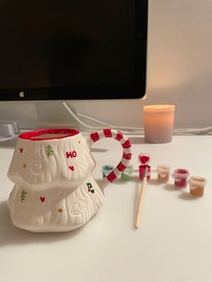 a computer monitor sitting on top of a desk next to candy canes and marshmallows