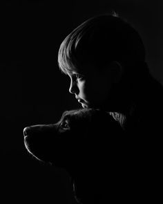 a little boy that is standing next to a dog