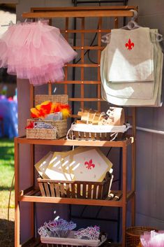 an umbrella and other items are displayed on a shelf in front of a house with pink tulle