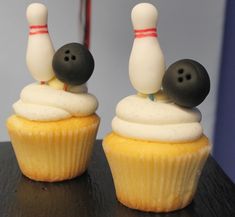 two cupcakes with bowling pins sticking out of them