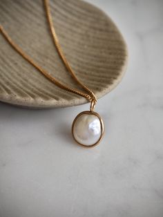 This necklace features a beautiful white baroque cultured freshwater pearl (AAA) set in 18 k solid gold that hangs from a delicate and high quality gold filled chain. This necklace is a timeless piece that makes a perfect gift for many occasions. Pearl is the birthstone for the month of June and makes a lovely birthday gift as well. Minimal simple design, effortlessly chic. Wear it on its own or layer it with other necklaces. Made using the highest quality USA and UK sourced materials. 📦 Eco-friendly packing I try my best to use as little plastic as possible in my packaging. Each order will arrive wrapped in a sweet eco-friendly and biodegradable glassine paper bag, ready for gift giving.  I use ONLY 100% recyclable mailers and 100% biodegradable product packaging. D e t a i l s : => Meta Graceful Pearl Pendant Jewelry As A Gift, Graceful Gold Necklace With Pearl Charm, Elegant Oval Necklace With Pearl Charm, Fine Jewelry Pearl Drop Pendant Necklace, Graceful Pearl Pendant Necklace As A Gift, Fine Jewelry Baroque Pearl Necklace Gift, Pearl Necklace With Oval Pendant And Pearl Drop, Minimalist Baroque Pearl Necklace With Pendant, Gold Necklace With Pearl Chain And Oval Pendant