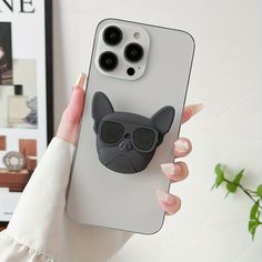 a person holding up a phone case with a cat on it