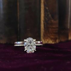 a diamond ring sitting on top of a velvet surface