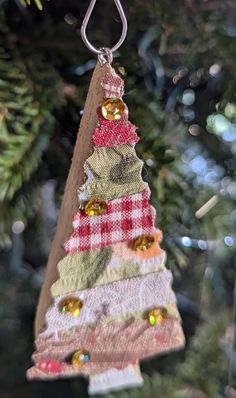 an ornament hanging from a christmas tree with ornaments on it's sides