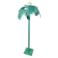 a green palm tree with a white ball on it's top and two lights at the base