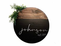 a round wooden sign with the word, personalized on it and a plant growing out of it