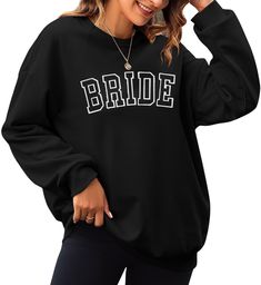 a woman wearing a black sweatshirt with the word bride written on it in white letters