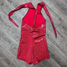 Made of our holographic red shattered glass spandex, this halter romper hugs the body, but offers plenty of stretch. The halter top ties at the back of the neck. Our seamless front design is extremely comfortable and prevents camel toe. Wear this to a rave, to a festival, or an aerial performance. this is perfect for your Olivia Rodrigo outfit. Fitted Halter Neck Jumpsuits And Rompers For Party Season, Fitted Halter Neck Jumpsuit For Party Season, Red Fitted Halter Top For Night Out, Fitted Red Halter Top For Night Out, Red Stretch Backless Jumpsuit, Party Stretch Halter Top With T-back, Red Stretch Backless Jumpsuits And Rompers, Stretch T-back Halter Top For Party, Metallic Fitted Sleeveless Jumpsuits And Rompers