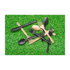 forks, spoons and knives are laid out on the grass with black plastic utensils