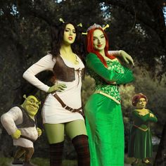 two women dressed in costume standing next to each other with green and brown costumes on