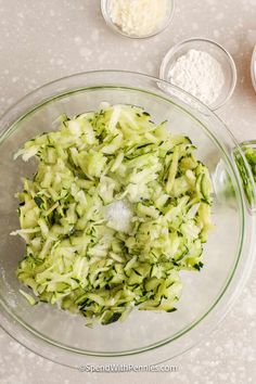 a glass bowl filled with cucumber and other ingredients