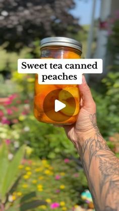 a person holding up a jar of tea with the words sweet tea caned peaches