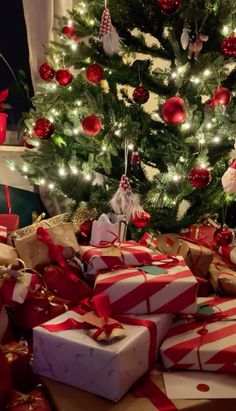 presents under the christmas tree are wrapped in red and white paper