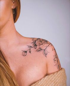 a woman with a flower tattoo on her shoulder